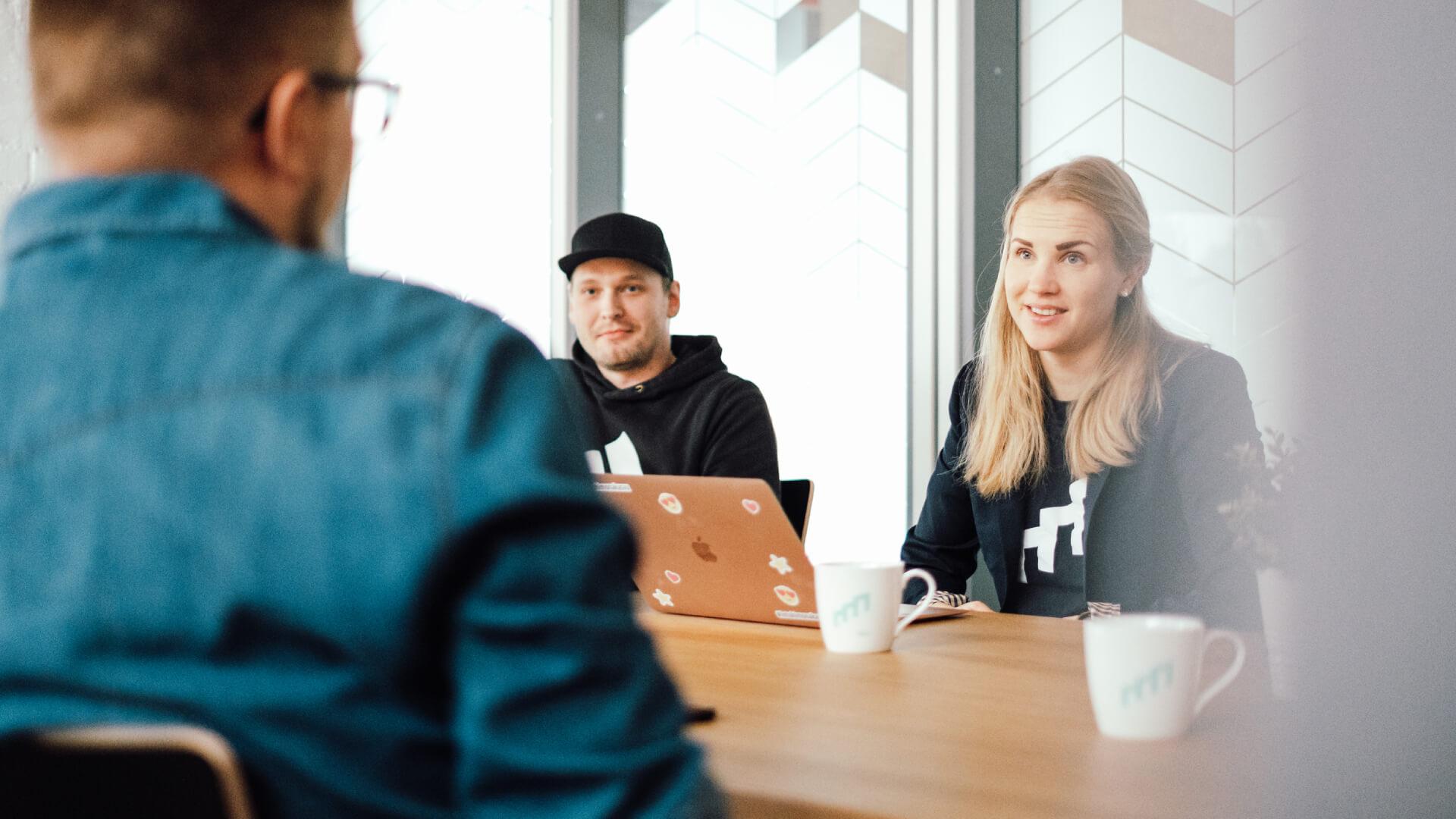 Myynninmaailman työntekijöitä pöydän äärellä keskustelemassa